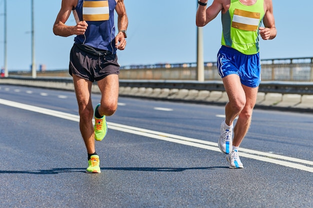 Männer in Sportbekleidung laufen auf der Straße