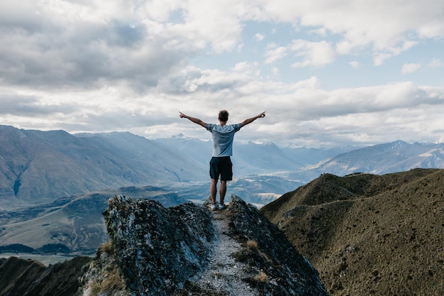 Foto männer in voller länge stehen auf dem berg gegen den himmel