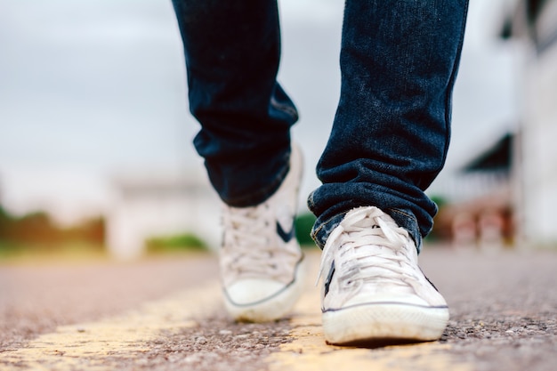 Männer Jeans und Sneaker Schuhe auf der Straße.