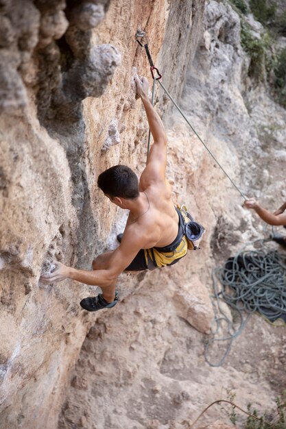 Männer klettern mit Sicherheitsausrüstung auf einen Berg climbing