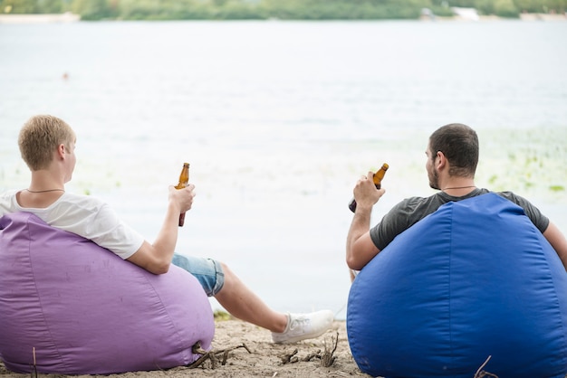 Männer mit bier entspannt auf sitzsäcken