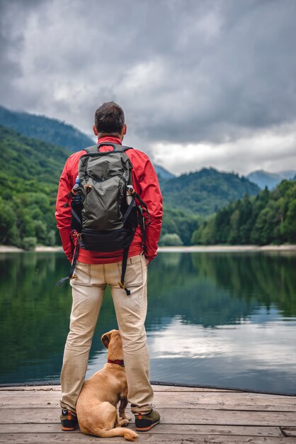 Männer mit einem Hund stehen am Pier am See