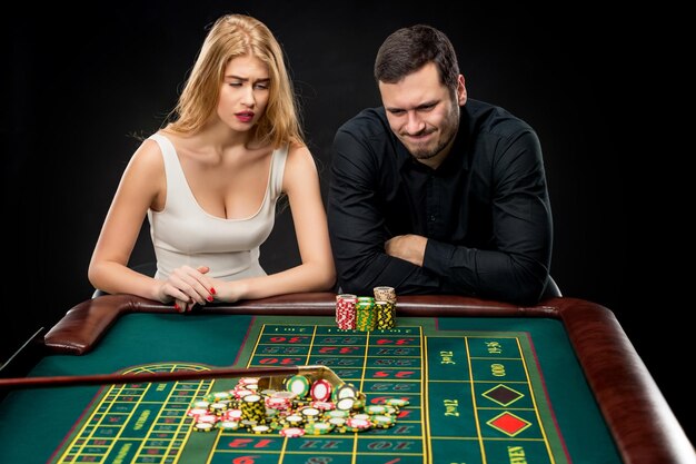 Männer mit Frauen, die im Casino Roulette spielen