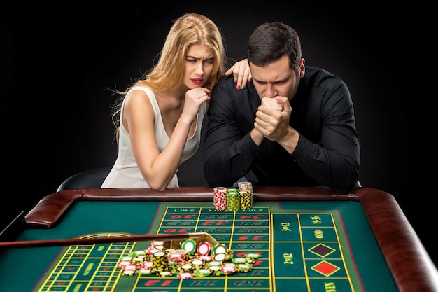 Männer mit Frauen, die im Casino Roulette spielen