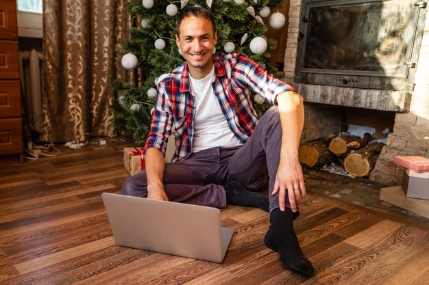 Männer mit Laptop in einem alten Holzhaus während der Weihnachtsferien