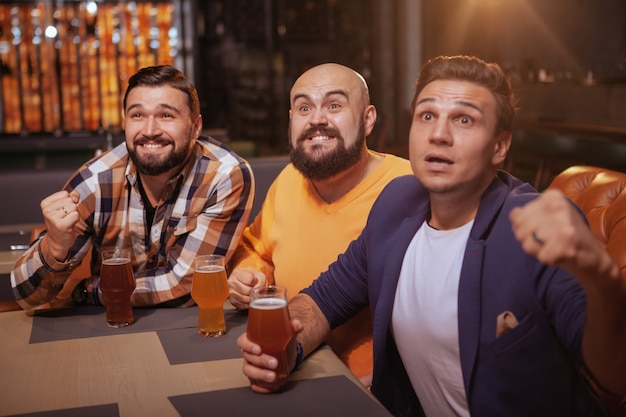 Männer schreien beim Fußballspiel in der Bierkneipe