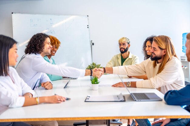 Männer schütteln sich die Hände und schließen einen Deal während eines Treffens in einem Coworking