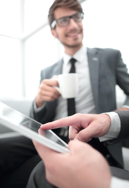 Männer sitzen im Büro mit Tablet