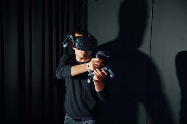 Männer spielen mit Virtual-Reality-Brillen, halten Controller in ihren Händen