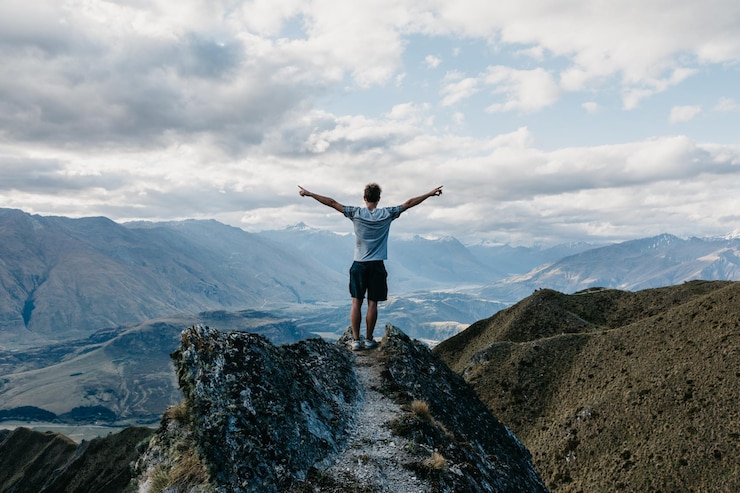 Foto männer stehen in voller länge auf dem berg vor dem himmel