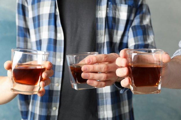 Männer trinken, Prost. Gläser Whisky gegen Blau