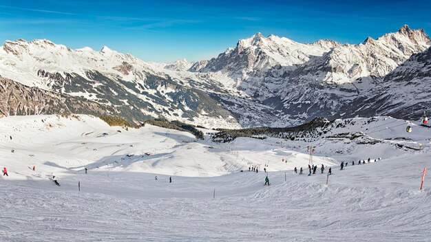 Männer und Frauen auf Skiern und Snowboards bei Freizeitaktivitäten im Wintersportort in den Schweizer Alpen