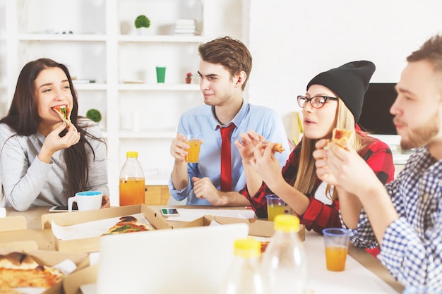 Männer und Frauen, die am Arbeitsplatz essen