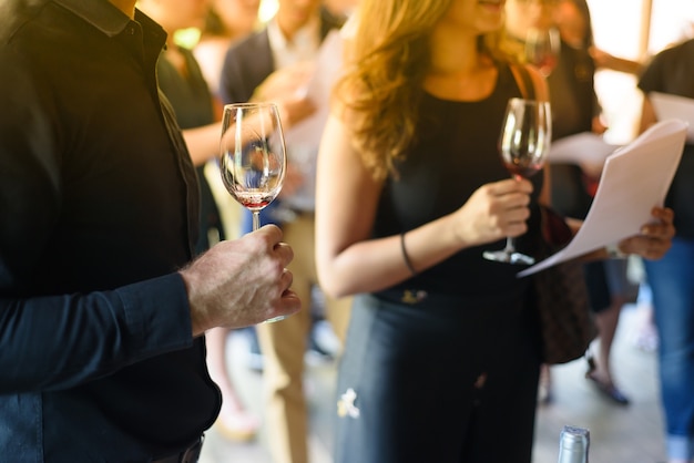 Männer und Frauen halten ein Glas