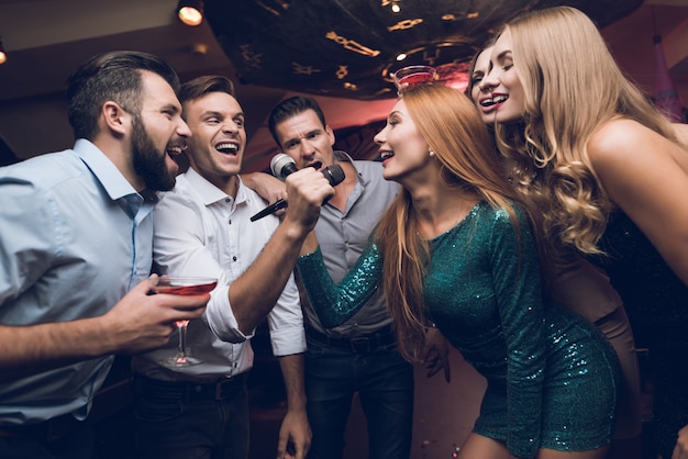 Männer und Frauen im Club singen zusammen.