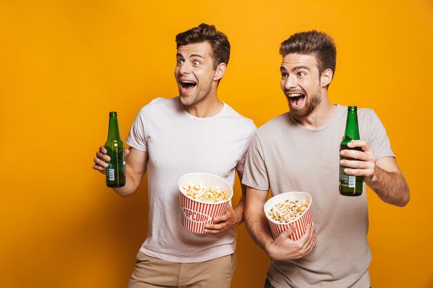 Männerfreunde, die Bier trinken, das Popcorn isst.