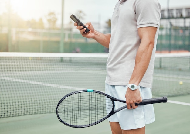 Männerhände und telefon auf dem tennisplatz für social-media-kommunikation oder zum chatten im sport für ein spiel oder ein spiel