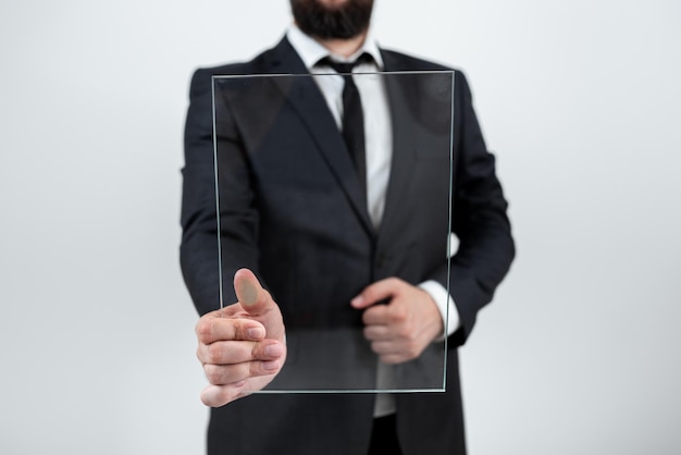 Männlich Corporate Holding und zeigt auf transparentes Glas und zeigt wichtige Ankündigung Geschäftsmann trägt Anzug mit rechteckigem Brett und Förderung der Marke