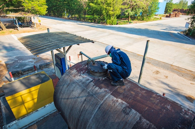 Männliche Arbeiter sind für die Inspektion der horizontalen Tankplatte der Ultraschalldickenoberseite des Lagertanks