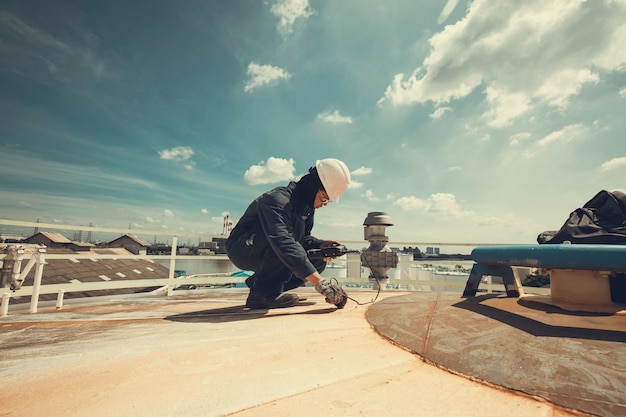 Männliche Arbeiter sind für die Inspektion der Ultraschalldicke der Dachplatte des Lagertanks