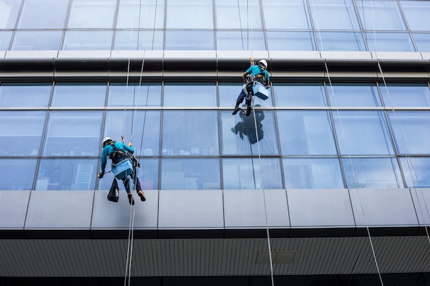 Männliche Arbeitskraft in der professionellen Glasreinigerunterlegscheibe des Overalls