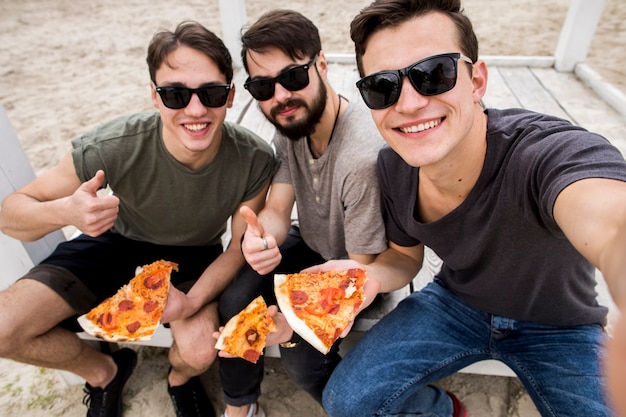 Foto männliche freunde, die selfie mit pizza nehmen