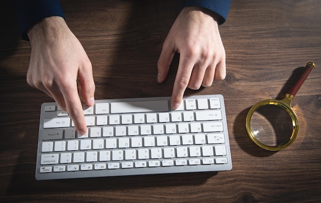 Männliche Hände, die Computertastatur eingeben Internet-Suchkonzept