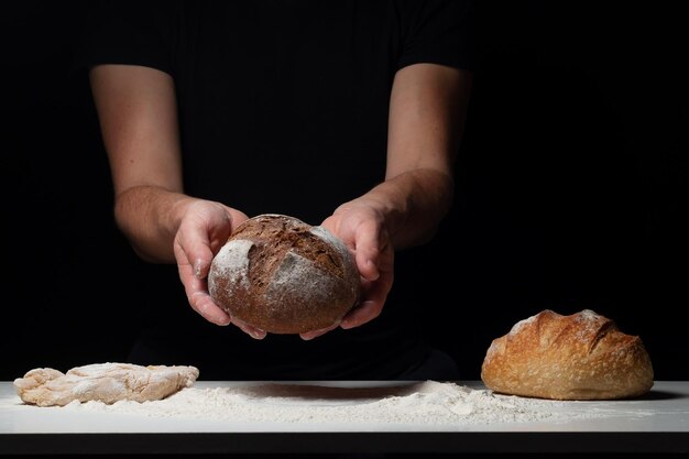 Männliche Hände, die Laib hausgemachtes Roggenbrot halten. Konzept für Bäckereiplakat oder Cover. Gesundes Essen