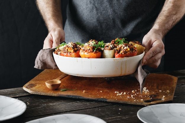 Männliche Hände halten gekochte gefüllte Paprika Gesundes vegetarisches Essen