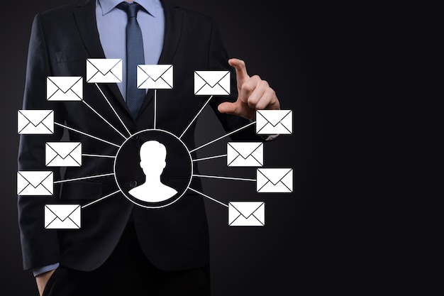 Männliche Hand, die Briefsymbol, E-Mail-Symbole hält. Kontaktieren Sie uns per Newsletter-E-Mail und schützen Sie Ihre persönlichen Daten vor Spam-Mails. Kundendienst-Callcenter kontaktieren Sie uns.E-Mail-Marketing und Newsletter.
