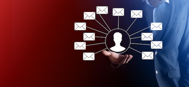 Männliche Hand, die Briefsymbol, E-Mail-Symbole hält. Kontaktieren Sie uns per Newsletter-E-Mail und schützen Sie Ihre persönlichen Daten vor Spam-Mails. Kundenservice-Callcenter kontaktieren Sie uns.E-Mail-Marketing und Newsletter