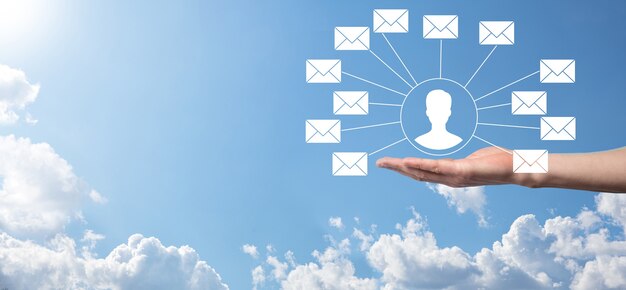 Männliche Hand, die Briefsymbol, E-Mail-Symbole hält. Kontaktieren Sie uns per Newsletter-E-Mail und schützen Sie Ihre persönlichen Daten vor Spam-Mails. Kundenservice-Callcenter kontaktieren Sie uns.E-Mail-Marketing und Newsletter