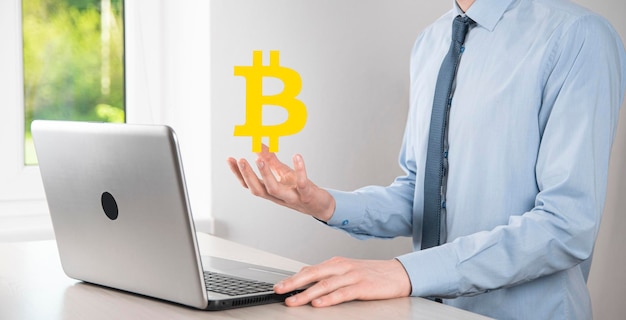 Männliche Hand, die ein Bitcoin-Symbol auf blauem Hintergrund hält Bitcoin Cryptocurrency Digital Bit Coin BTC Currency Technology Business Internet Concept