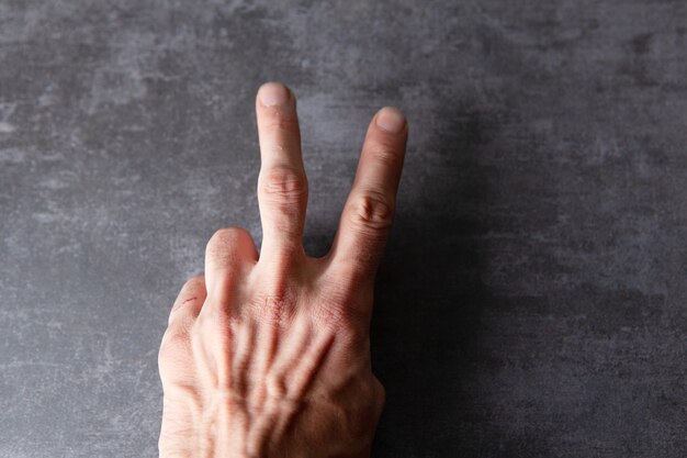 Foto männliche hand, die friedenszeichen zeigt