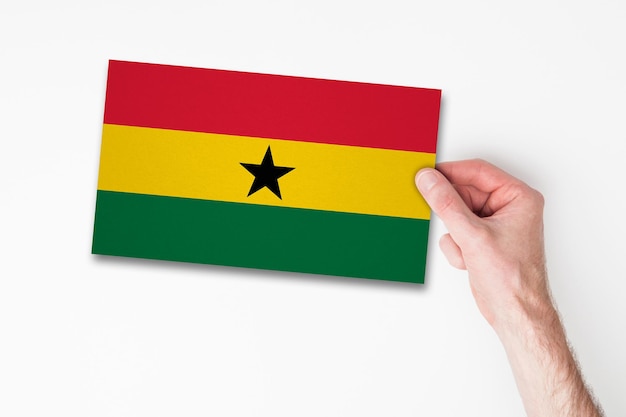 Männliche Hand, die Ghana-Flagge hält