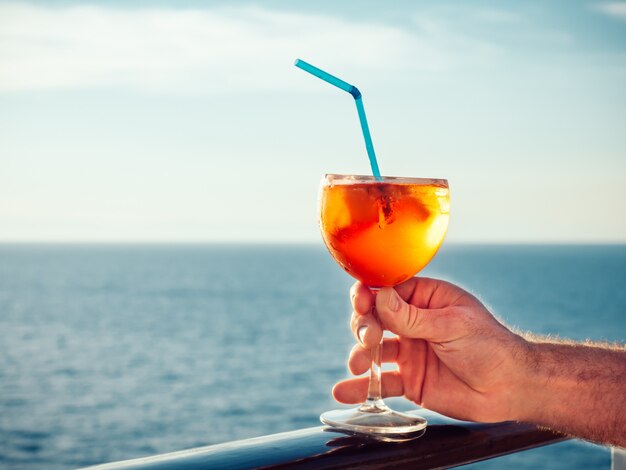 Männliche Hand mit einem Glas schönen rosa Cocktail