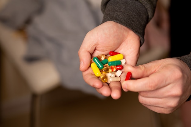 Männliche Hand mit Multivitaminen und täglichen Ergänzungen für ein gesundes Leben