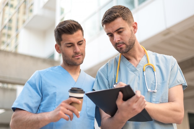 Männliche Krankenschwester mit Stethoskop und Kaffee