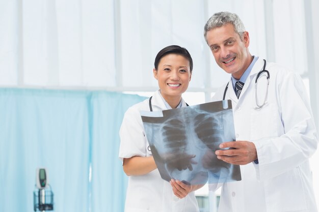 Männliche und weibliche Doktoren, die Röntgenstrahl überprüfen