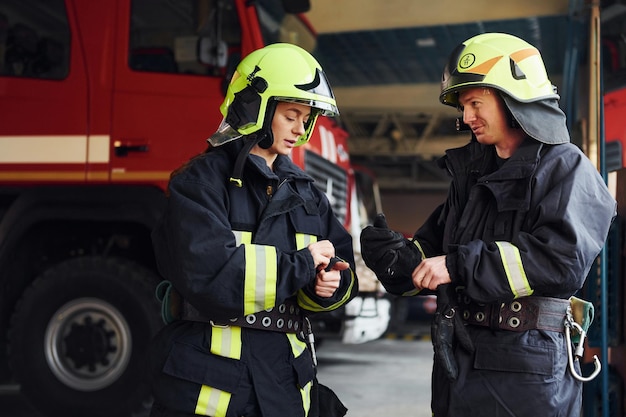 Männliche und weibliche Feuerwehrleute in Schutzuniform stehen zusammen