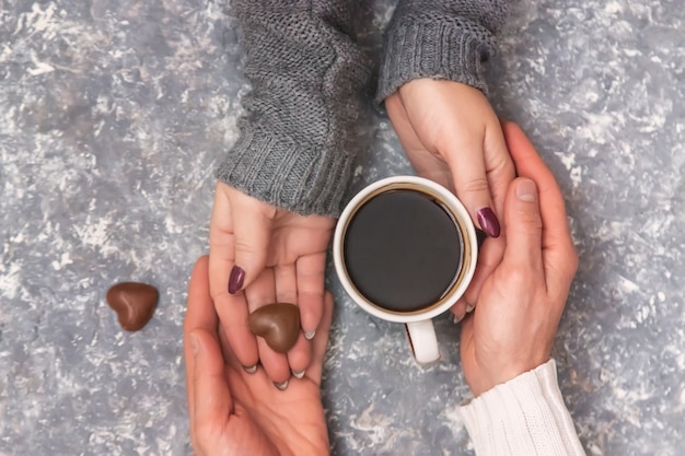 Männliche und weibliche Hände, die Tasse Kaffees halten. Selektiver Fokus