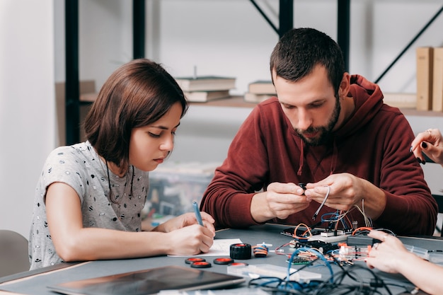 Männliche und weibliche Ingenieure, die DIY-Modell konstruieren.