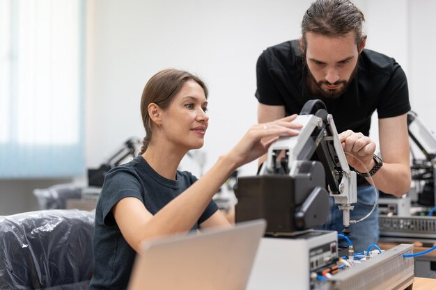 Männliche und weibliche Ingenieure testen und steuern KI-Robotermodelle im Robotiklaborraum der Akademie