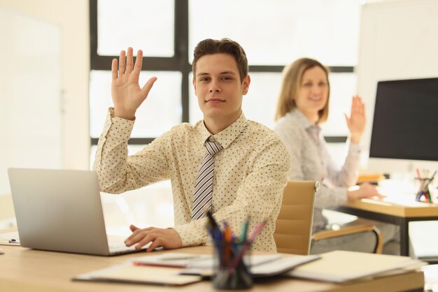 Männliche und weibliche Manager, die an ihrem Schreibtisch sitzen und Kunden bei der Büroarbeit begrüßen und