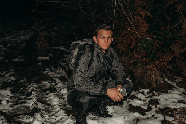 Männliche Wanderer in Kleidung zum Wandern und Taschenlampen auf dem Winterberg bei Nacht