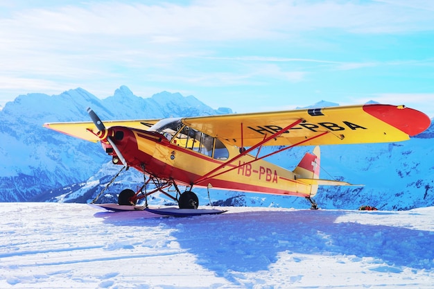 Männlichen, Schweiz - 31. Dezember 2013: Gelbes Flugzeug in den Bergalpengipfeln, Männlichen in der Winterschweiz