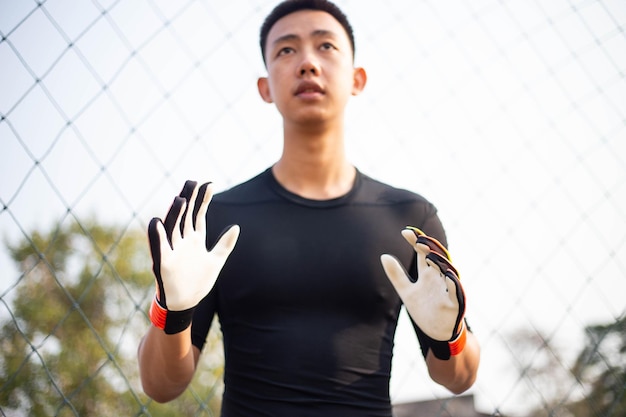 männlicher amateurspieler, der als torhüterposition trainiert, um den ball zu fangen