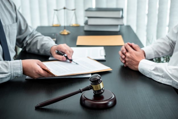 Männlicher Anwalt diskutiert Verhandlungsrechtsfall mit Kundentreffen mit Dokumentenkontakt im Gerichtssaal, Recht und Justizkonzept.