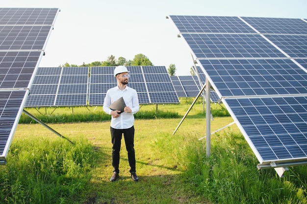 Männlicher Arbeiter Solarkraftwerk auf einem Hintergrund aus Photovoltaikpaneelen