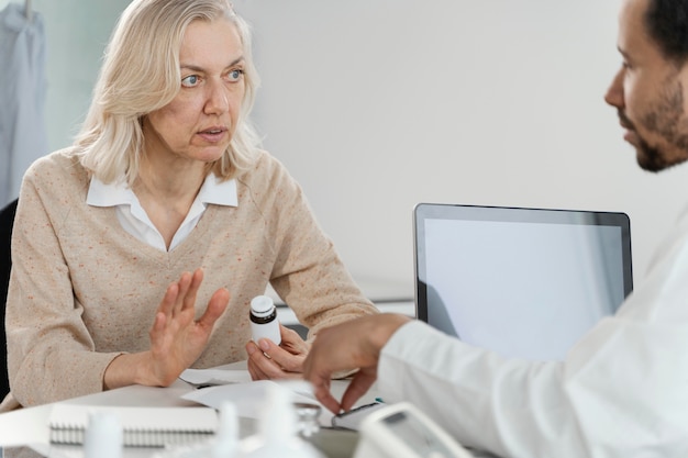 Männlicher Arzt, der dem Patienten Medikamente verschreibt